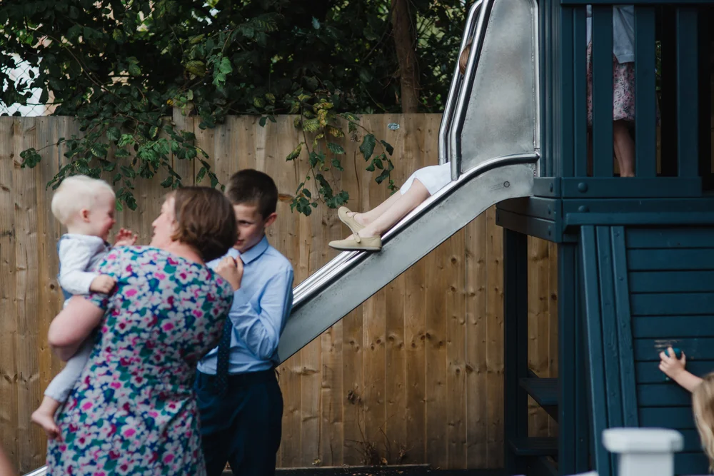 children play on a slide at a wedding