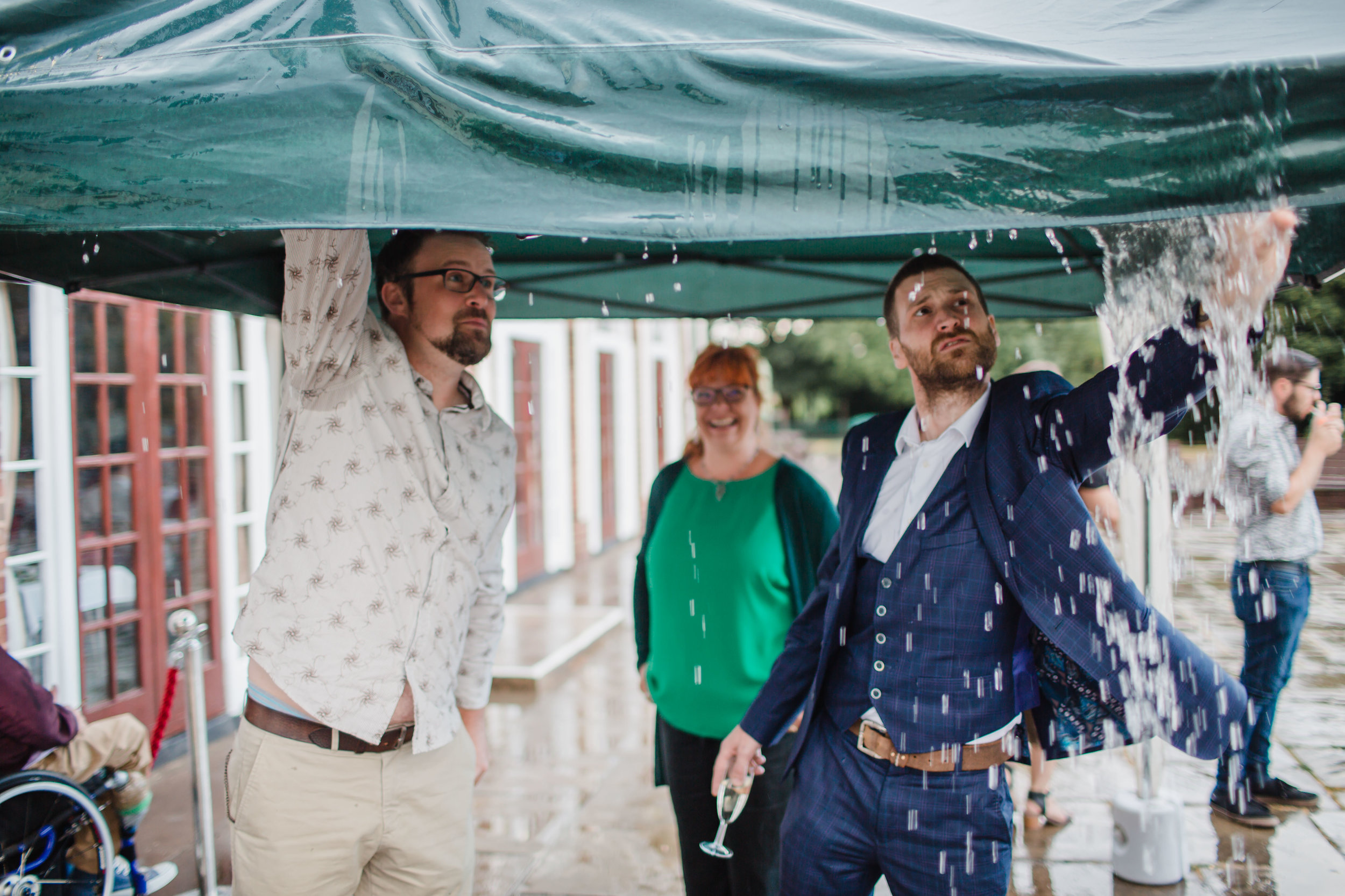 guests pushing water off the roof of a gazebo