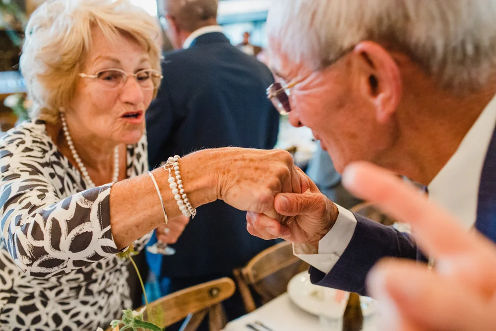 grandpa kisses grandma at a wedding