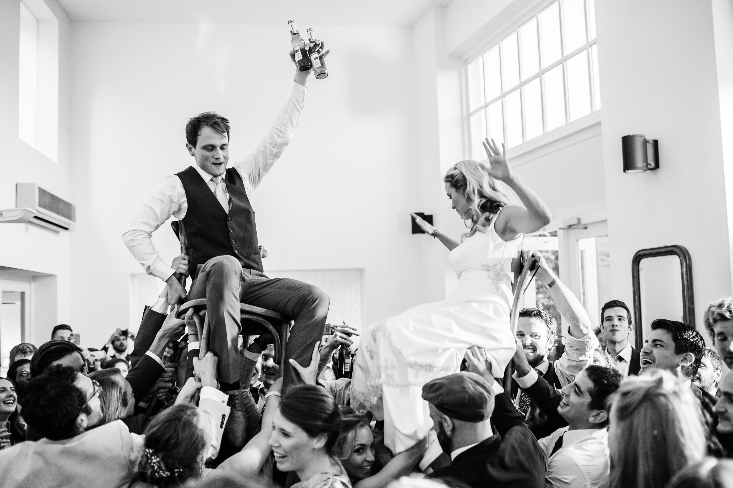a bride and groom are carried on chairs at Fazeley Studio.