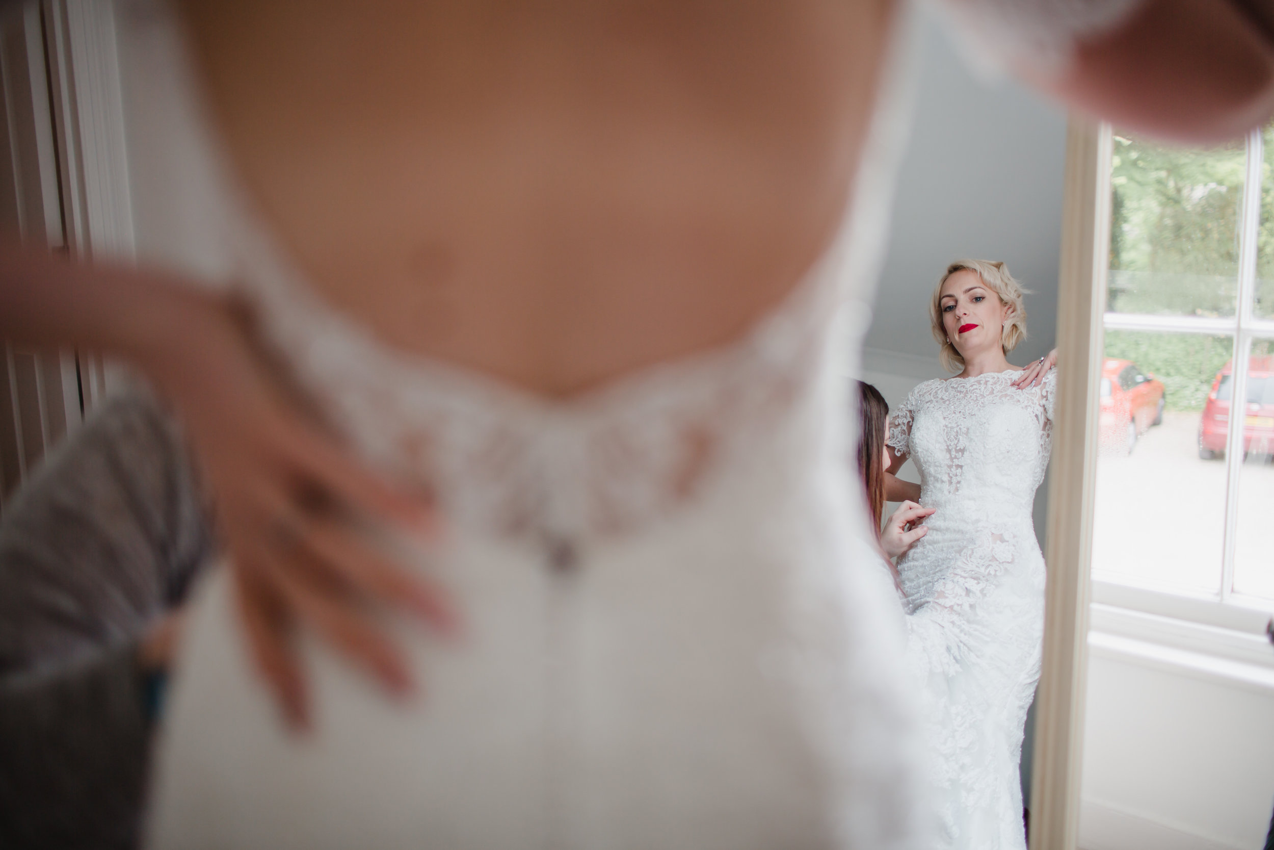 a bride looks at herself in a mirror at rosevine hotel truro cornwall