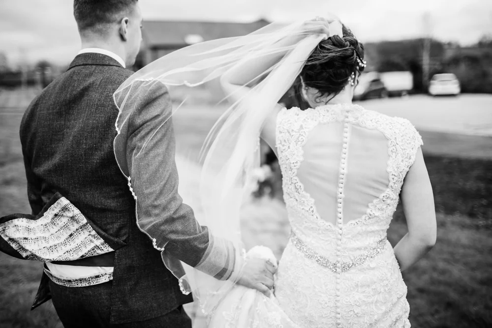 a bride and groom on a windy day