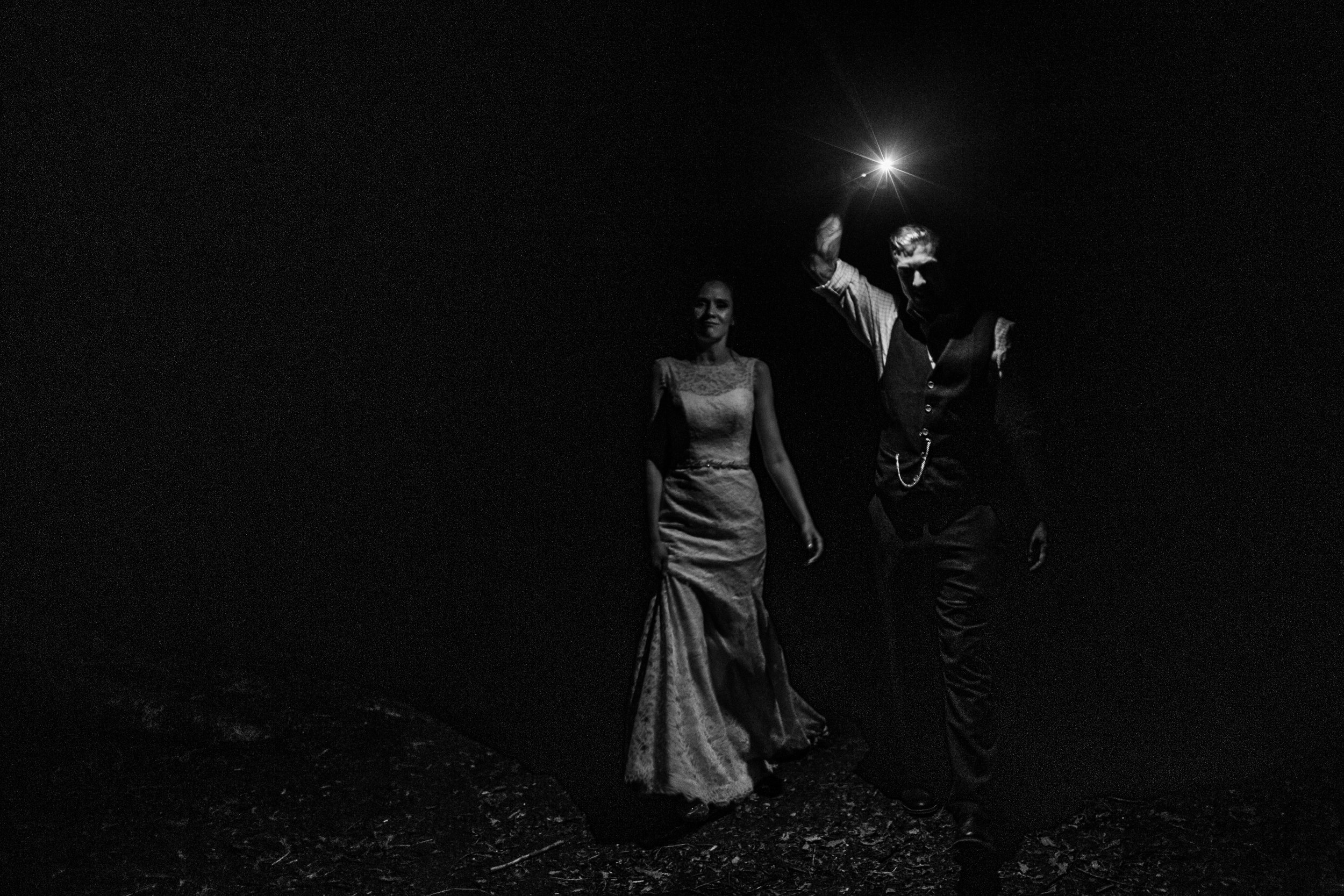 a bride and groom in the dark leading the way with an iphone torch at enchanted weddings birmimgham 