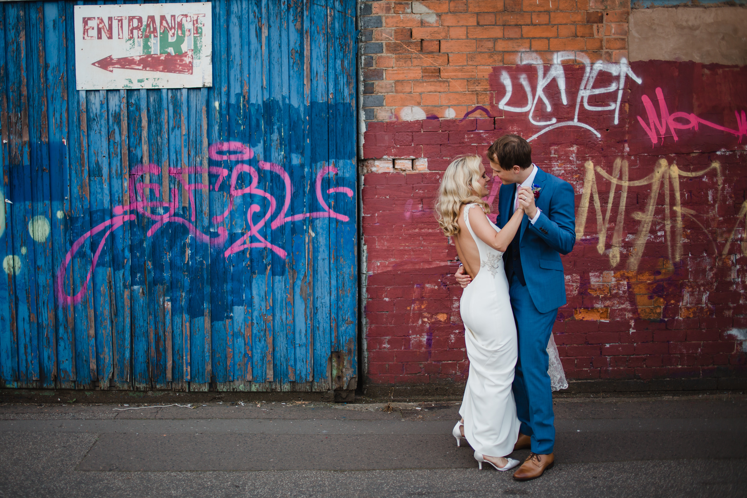  a bride and groom dance in front of graffiti ion their wedding day in digbeth Birmingham 