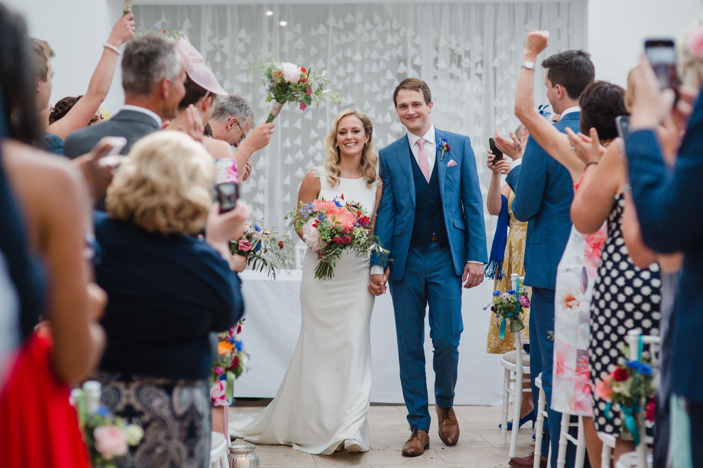 the bride and groom exit down the aisle after their wedding at fazeley studios birmimgham