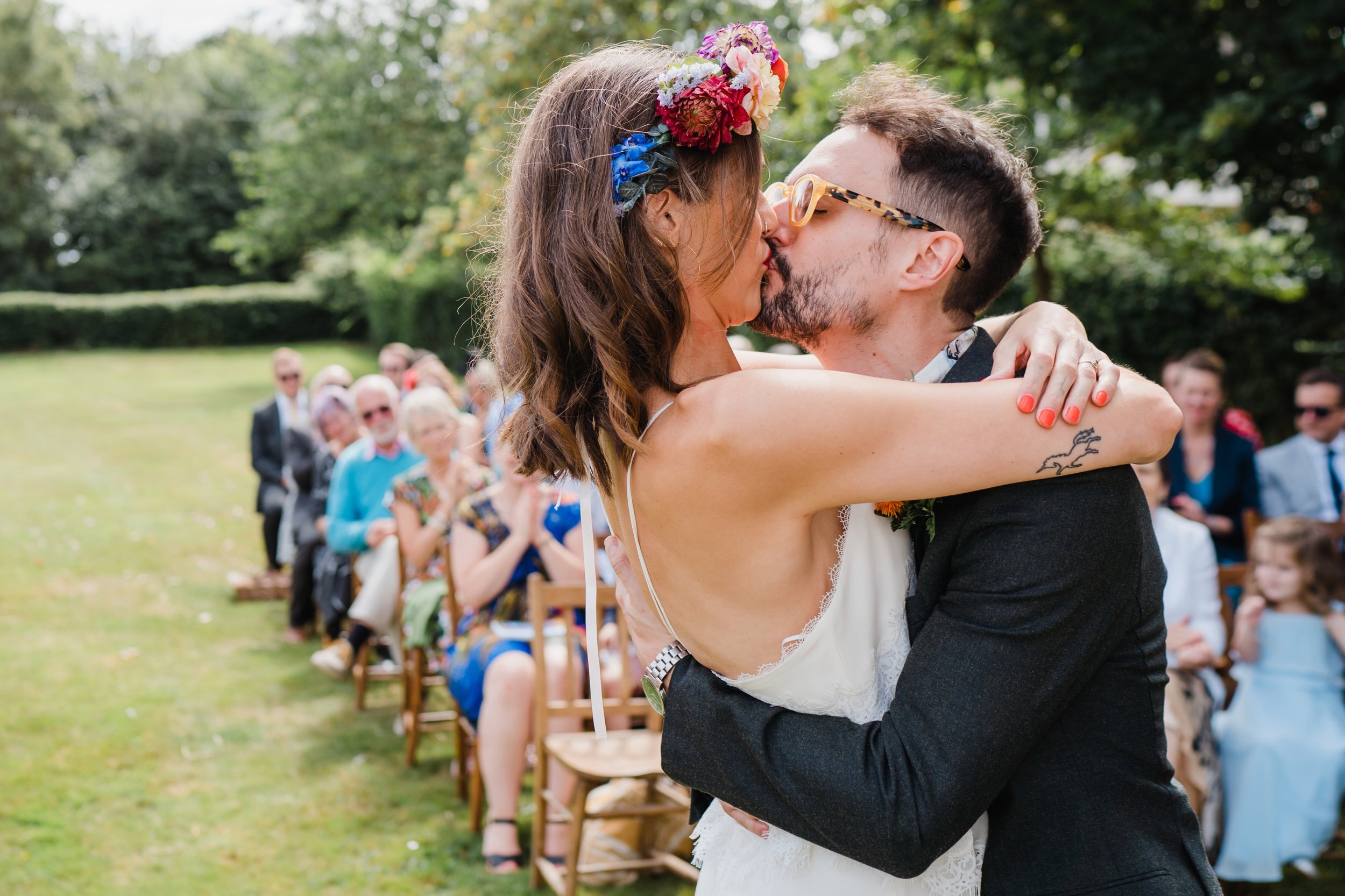 a bride and groom share a first kiss