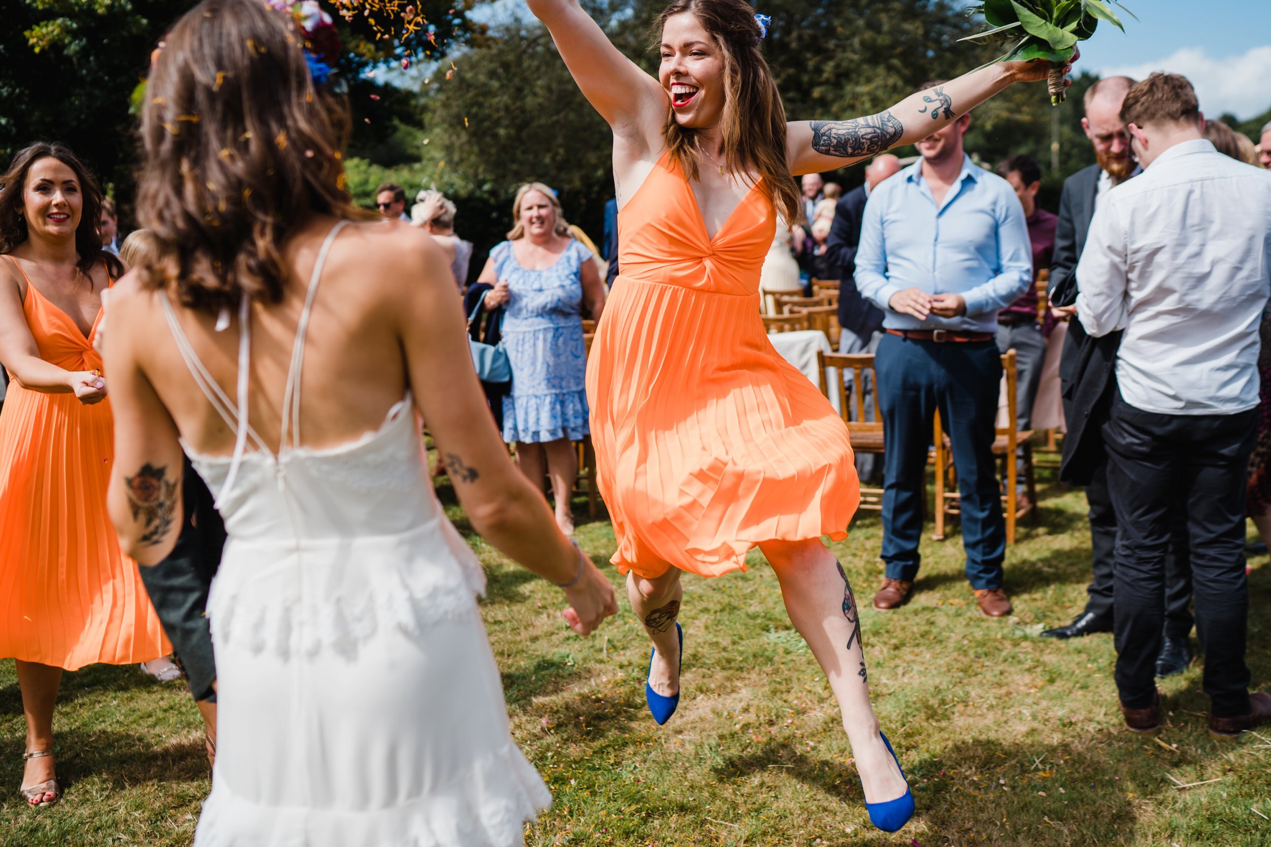 a bridesmaid jumps and throws confetti 