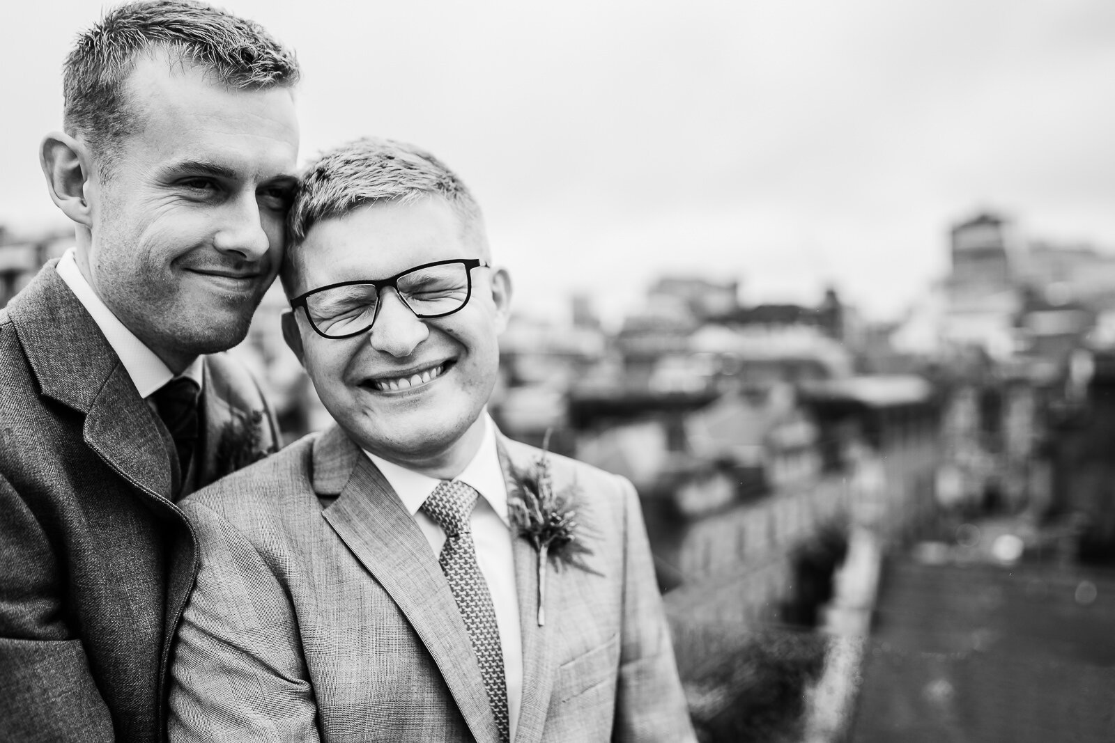 two grooms cuddle on a Manchester roof.