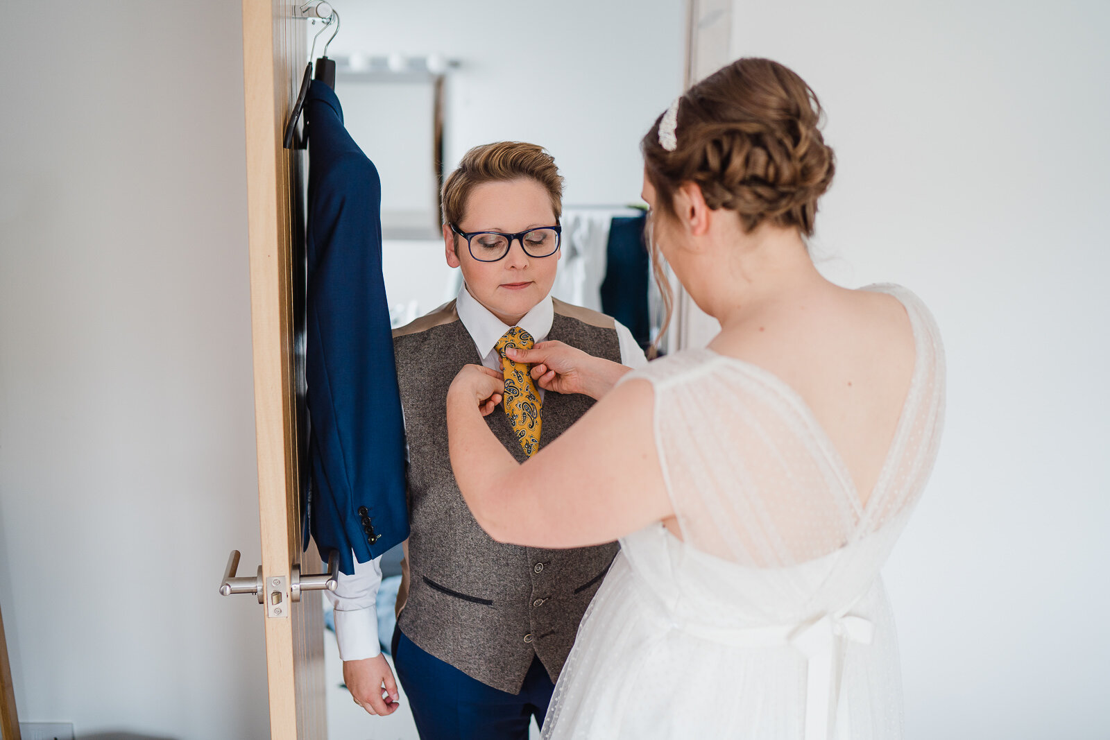 a bride adjusts a brides tie before the wedding 