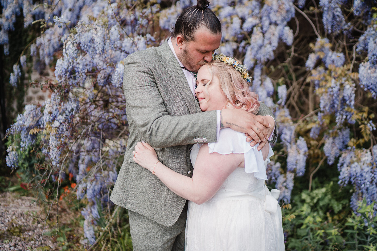 a couple in front of flowers at Lyde court