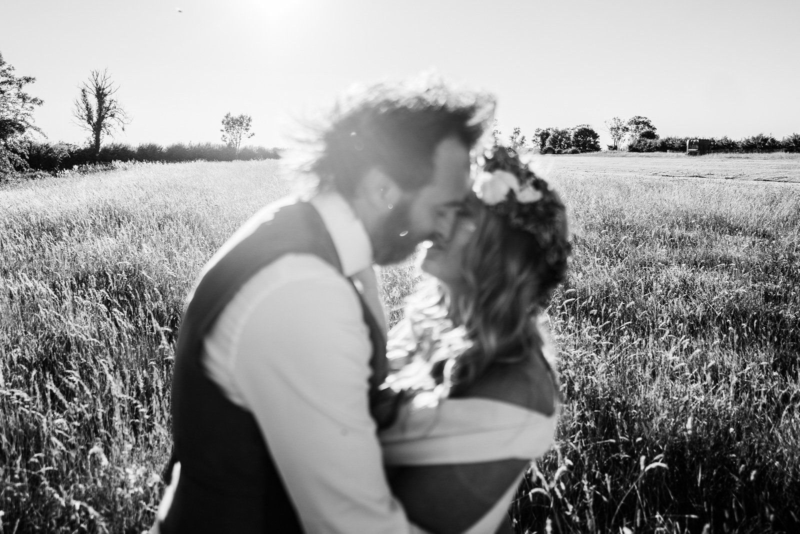 a couple kiss in a field - 2022 wedding round up no nonsense heartfelt wedding photography leeallenphotos