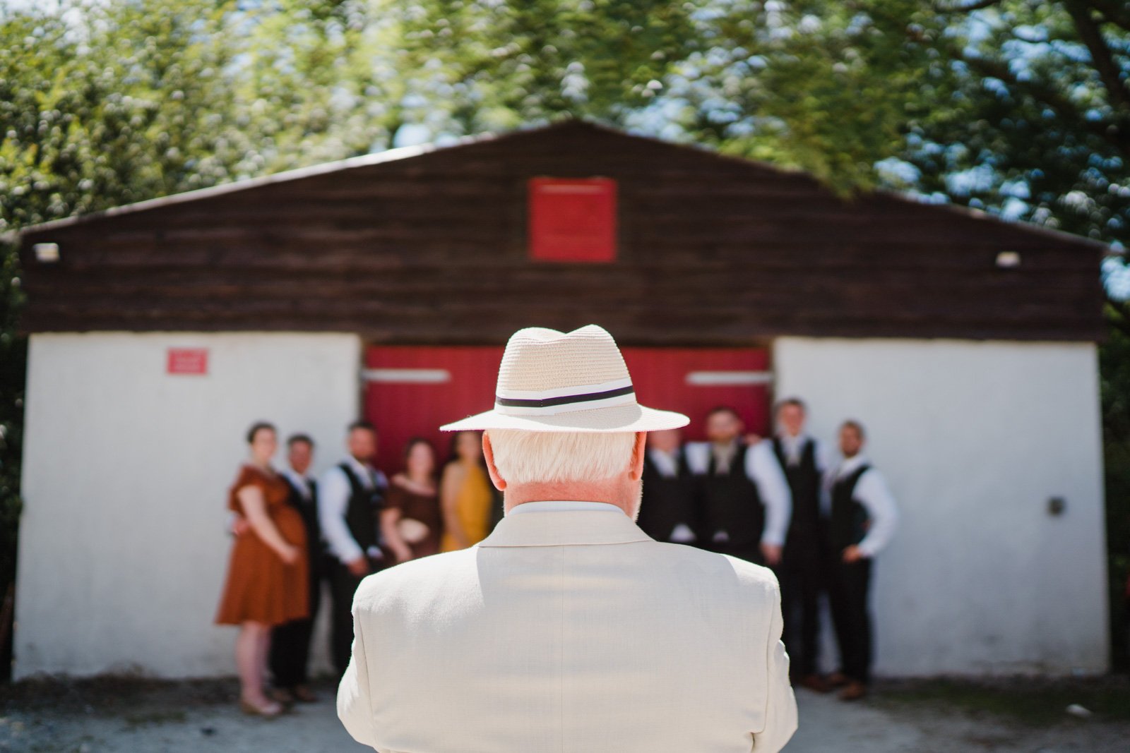 man in a hat takes a picture of a family at a wedding - 2022 wedding round up no nonsense heartfelt wedding photography leeallenphotos