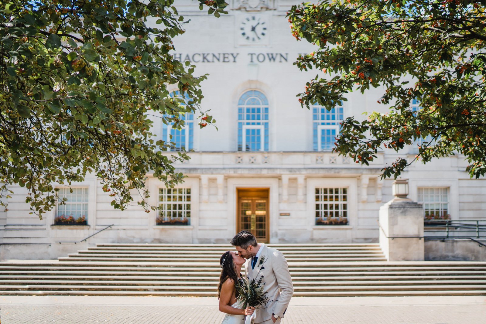 a bride and groom kiss outside hackney town hall in London - 2022 wedding round up no nonsense heartfelt wedding photography leeallenphotos 