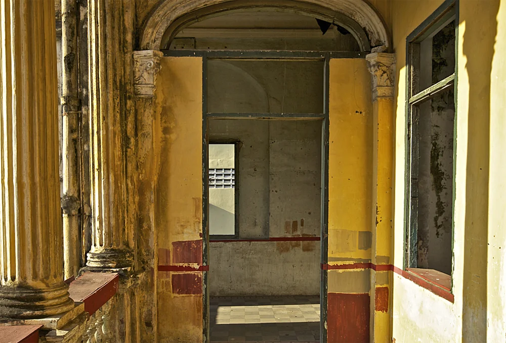 the sun shines bright on the foyet of an abandoned villa in phnom penh