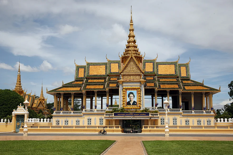 a lone motorbike glides past theentrance to the royal palace, phnom penh..