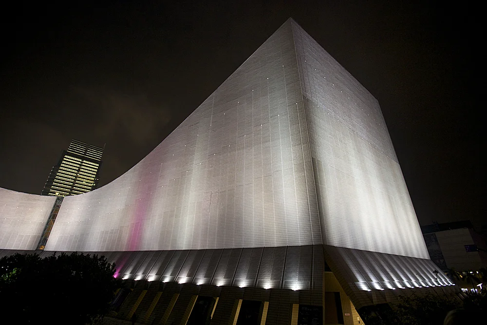 a wing of the hong kong museum of art lit up for the nightly harbor light show