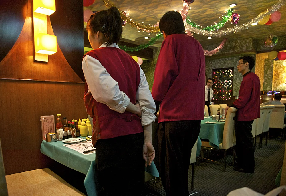 the wait staff prep tables for tomorrow at the goldfinch restaurant, a chinese steakhouse restaurant made famous in the 2000 wong kar wai film 'in the mood for love'