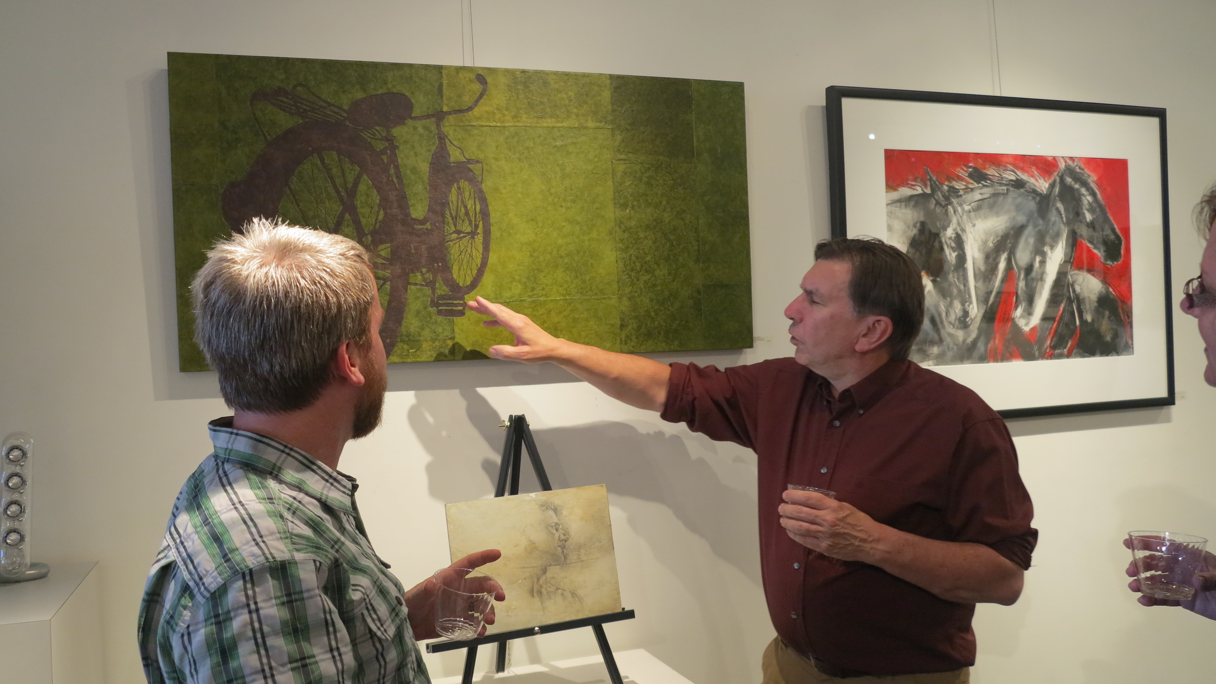 Artist Grant Penny telling a guest about his process. April 3rd, 2015 Pictured: Destination Unnecessary by Grant Penny , paper collage on cradled panel