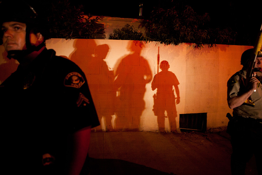  Police officers stand guard after protesters set fire to a trash bin.     