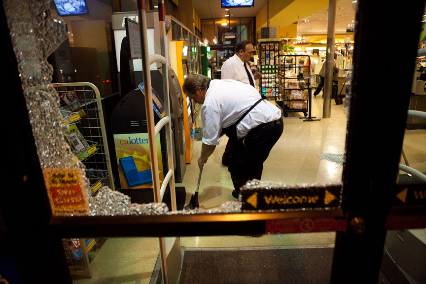  Vons employees clean broken glass from windows that were smashed by 
protesters after violence erupted.     