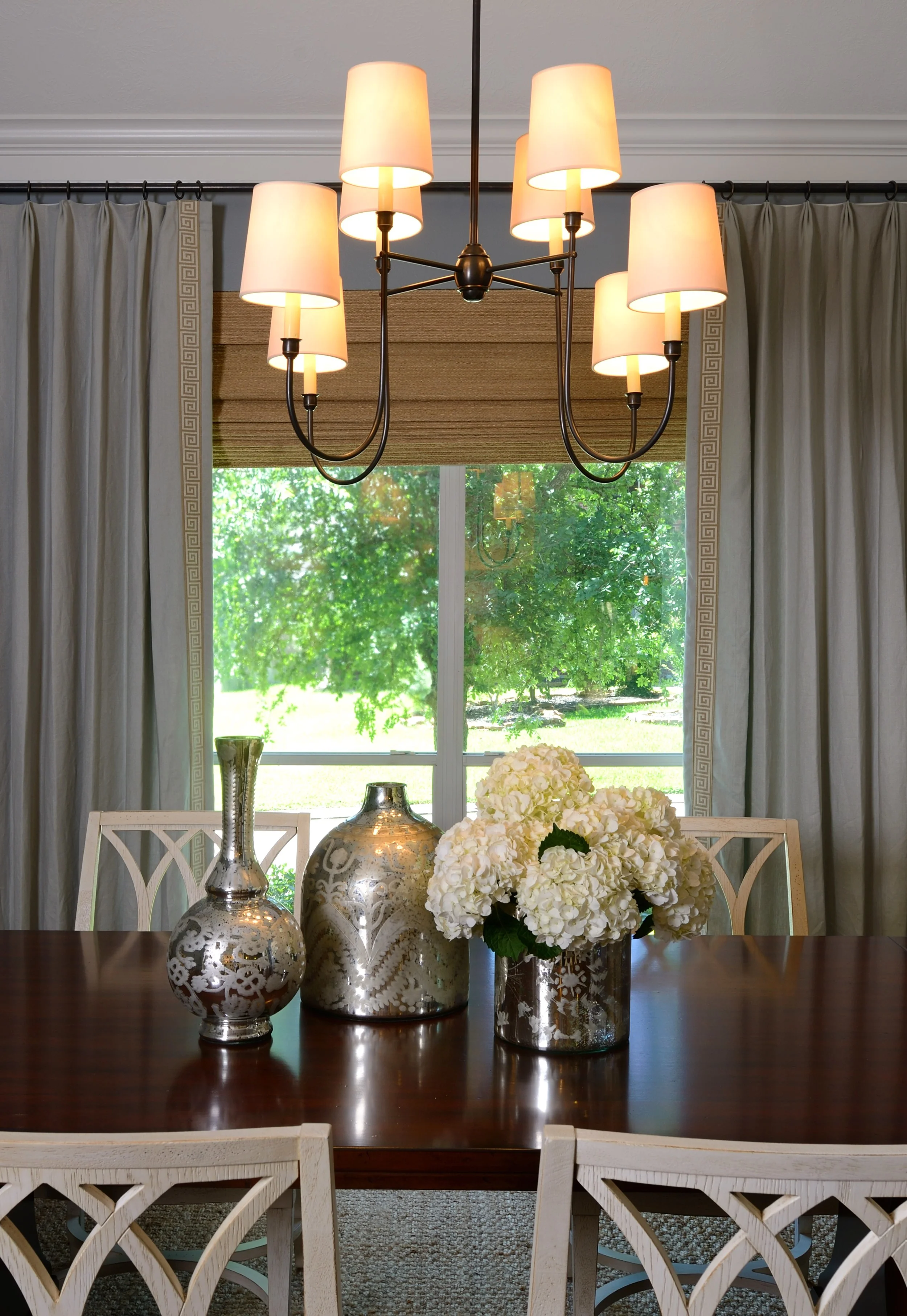 In this dining room remodel, interior designer Carla Aston... Re-did the floors; painted everything; took down dated wallpaper borders; got rid of all toasted tan color; remodeled the fireplace; paneled the front of the bar; added a new backsplash; and, of course, put in some beautiful lighting. ;-)