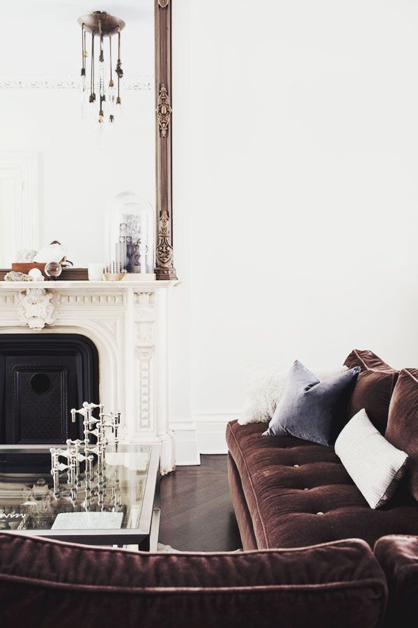 living room couch, fireplace, glass table, pillow, mirror | Designer: Michelle James / Image source: this is glamorous 