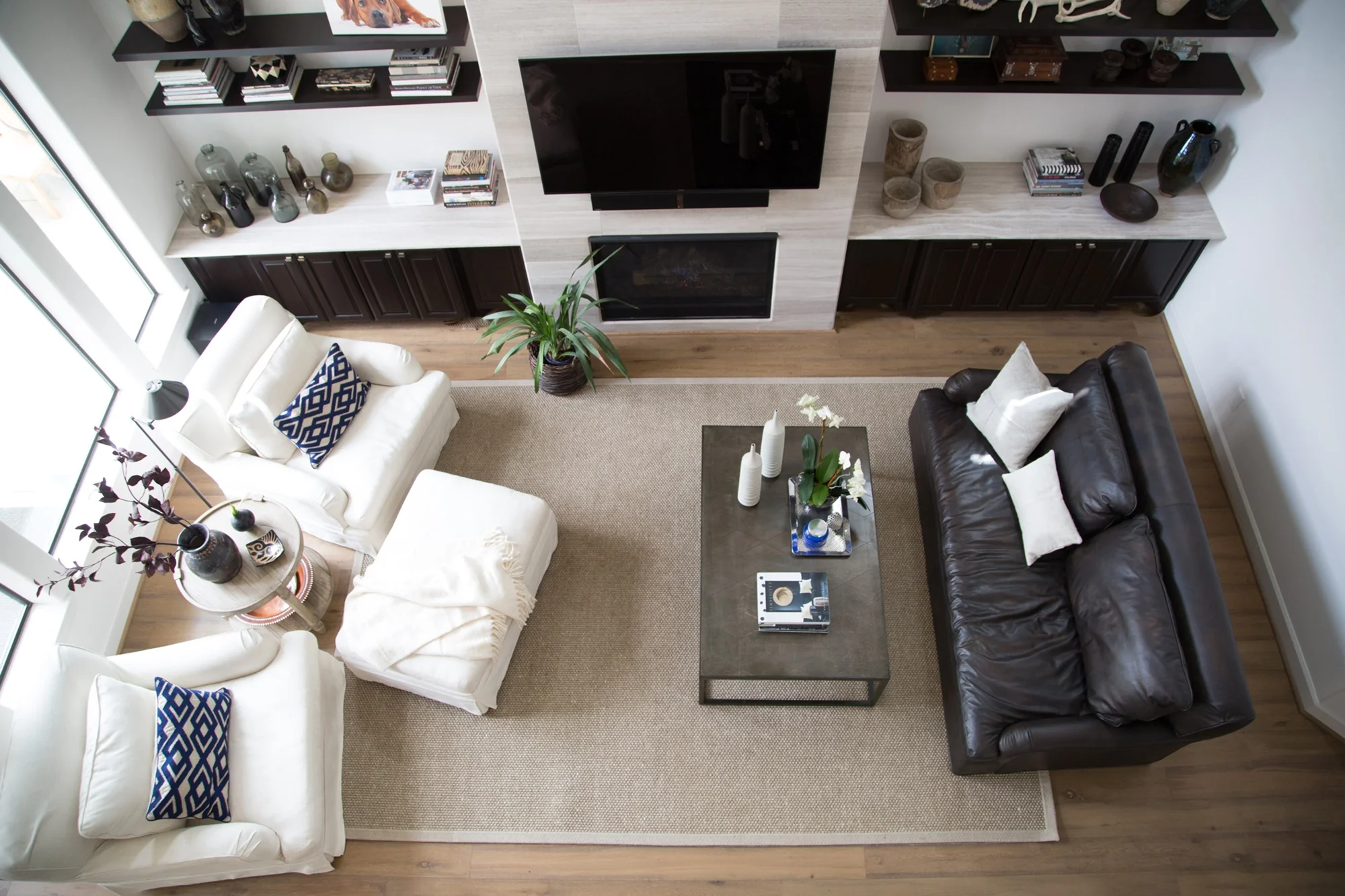  living room remodel; chair; Ottomans; leather sofa; shelving; fireplace; coffee table | Interior Designer: Carla Aston / Photographer: Tori Aston