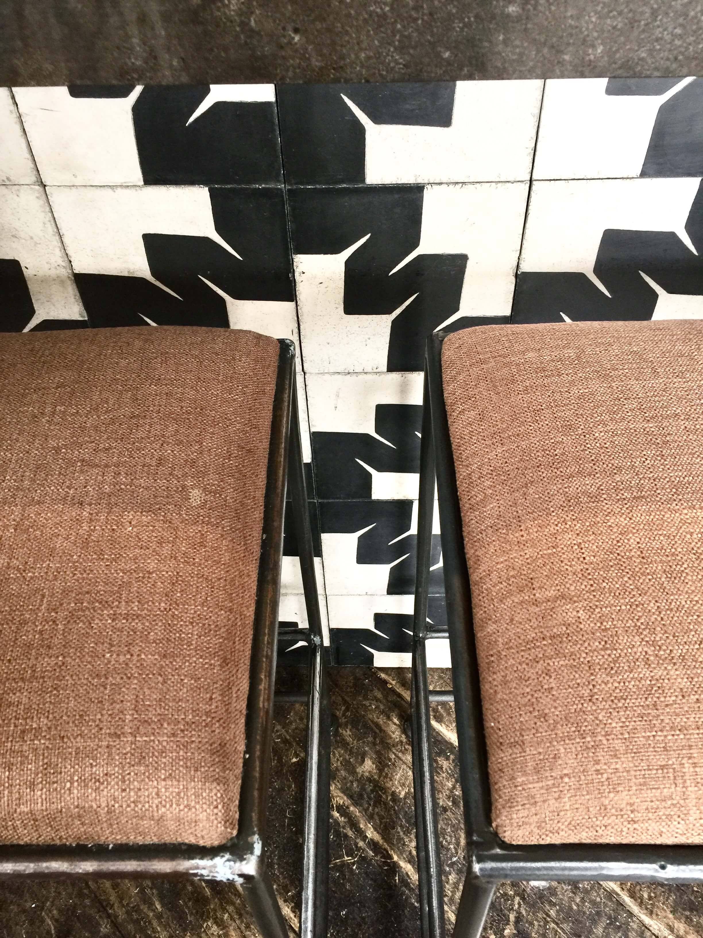 Graphic black and white tile at the bar face with rustic wood flooring