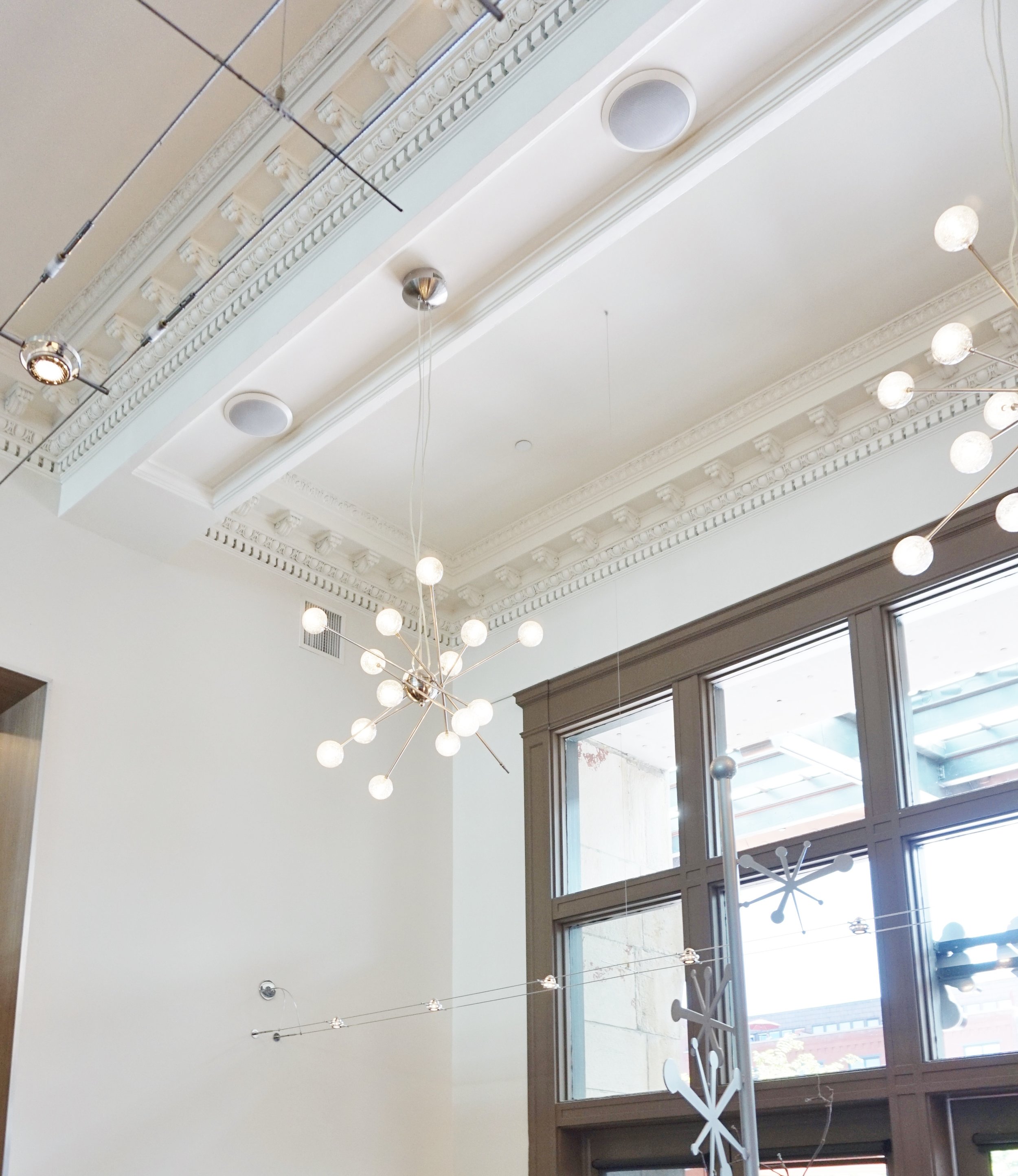 Mod lighting contrasts with the detailed moulding and architecture in Snooze | The Crawford Hotel.