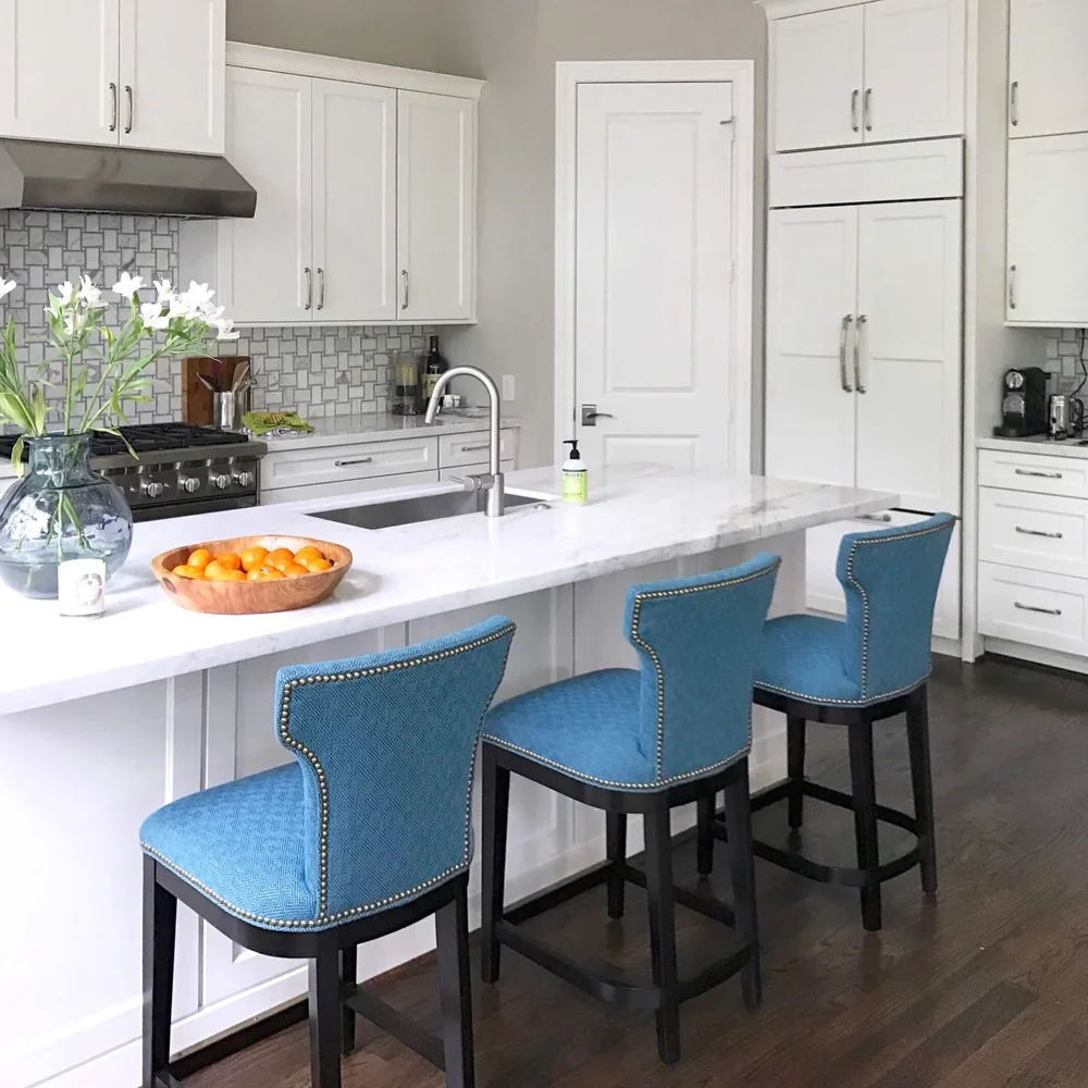 Colorful upholstery on the counterstools add style and interest in this white kitchen. Carla Aston, Designer #whitekitchen