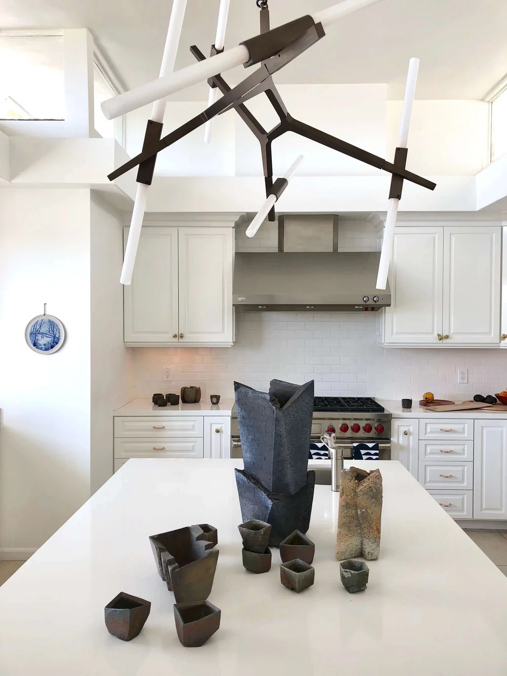 Statement modern lighting works well in this simple white kitchen at Casa Perfect in LA. #whitekitchen
