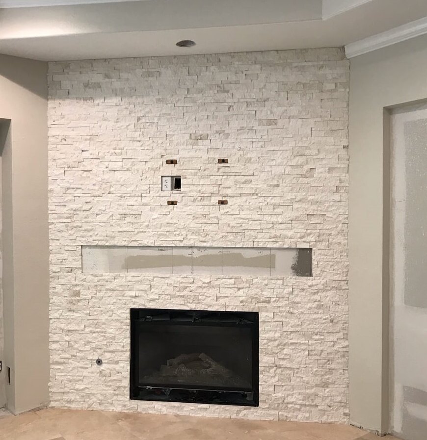 Light, neutral stacked stone covering the wall of the fireplace in this remodel project that was under construction at the time. A rustic mantel will be installed and tv mounted over the fireplace.