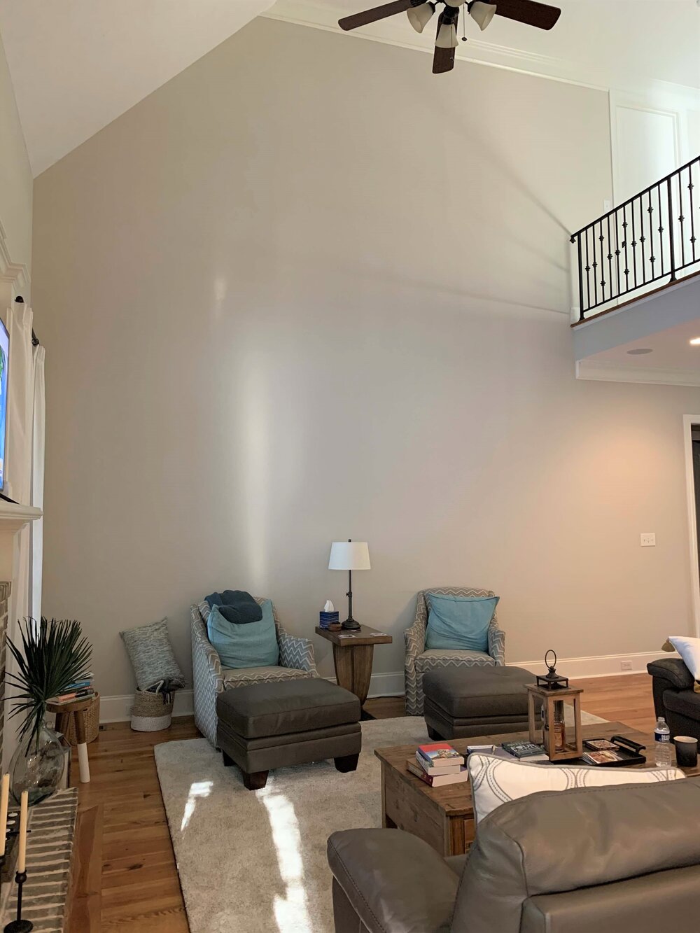 How do you decorate this two story high empty wall in a big living room space?