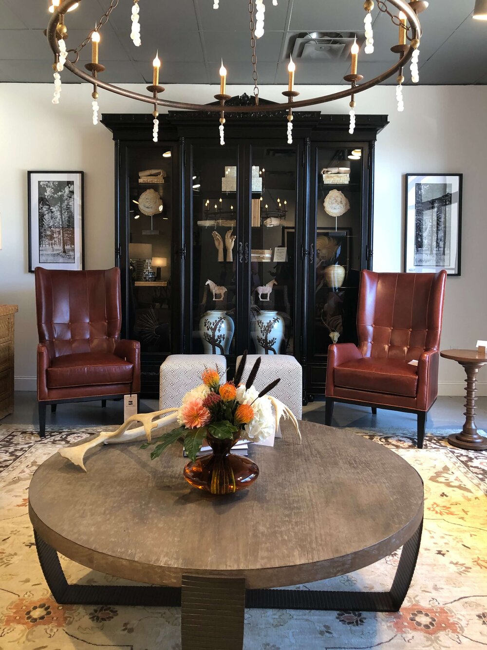 A display cabinet with two chairs in front is a great way to address a tall empty wall space.