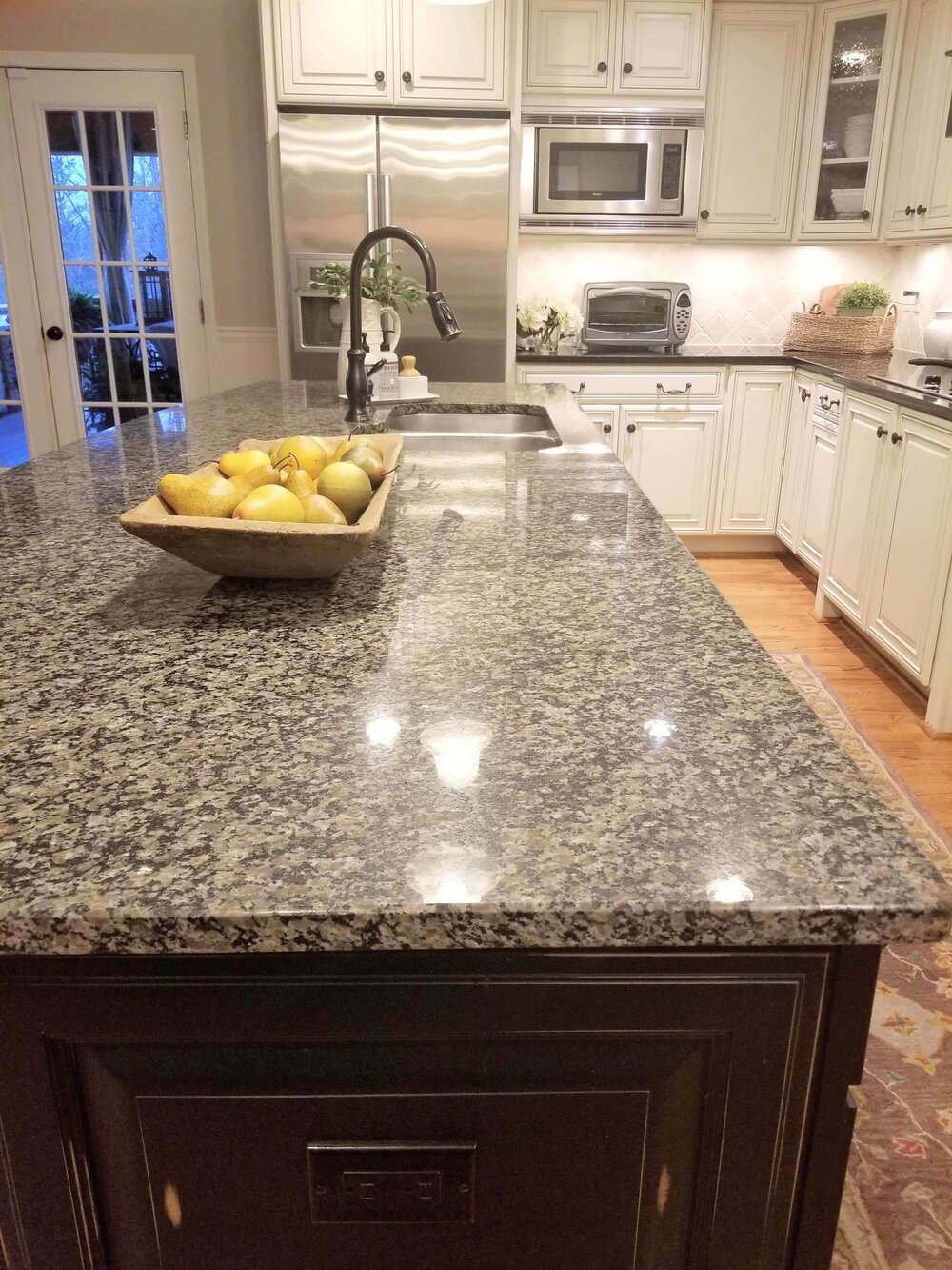 BEFORE REMODEL - Spotty granite on the island was busy and dated. Black granite is on the perimeter cabinets.