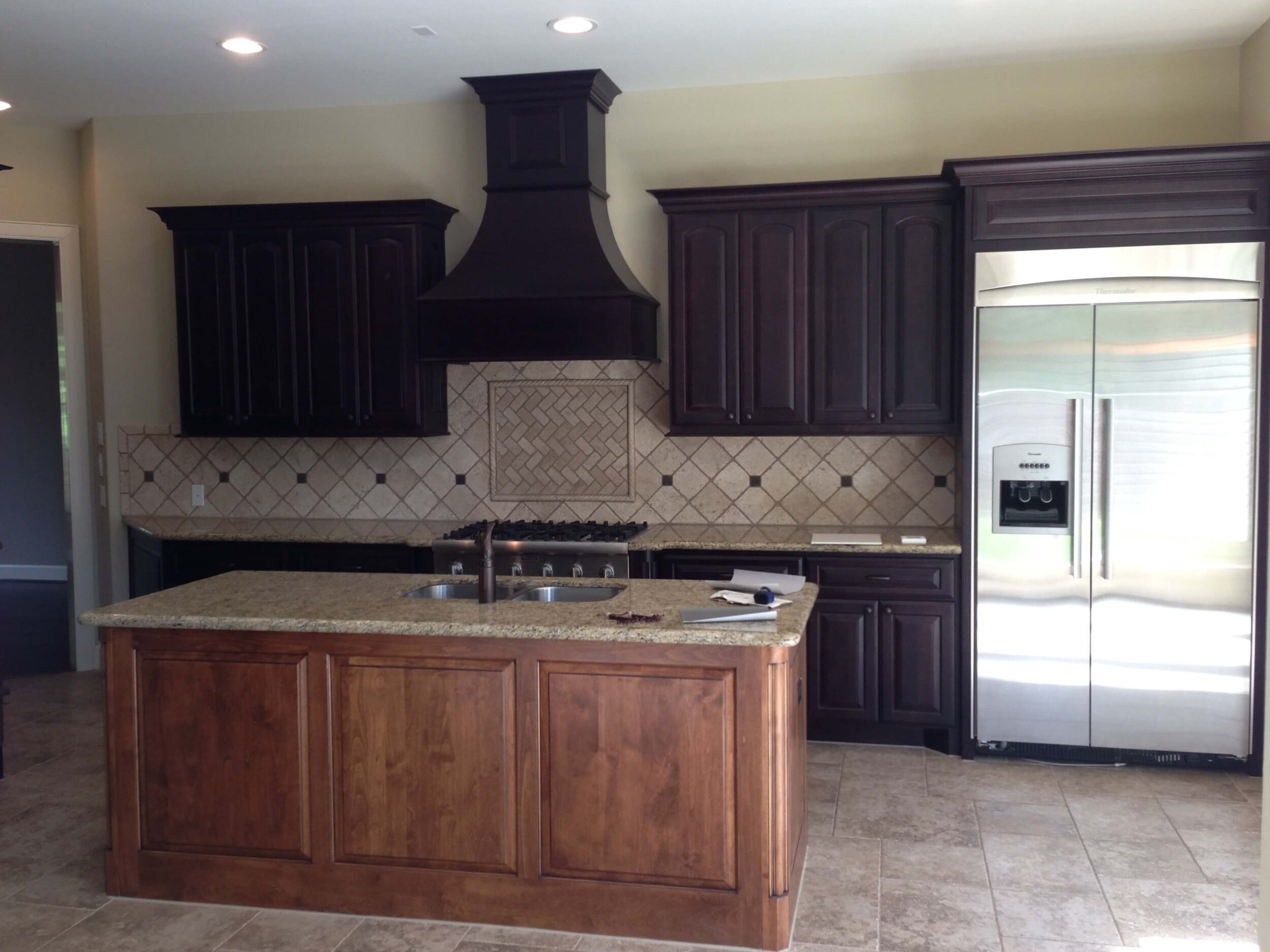 dark kitchen cabinet with light countertops and floor