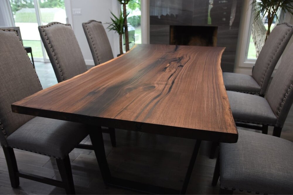 Live edge walnut table with modern base would work beautifully in a Tuscan style home to bring it more up to date.