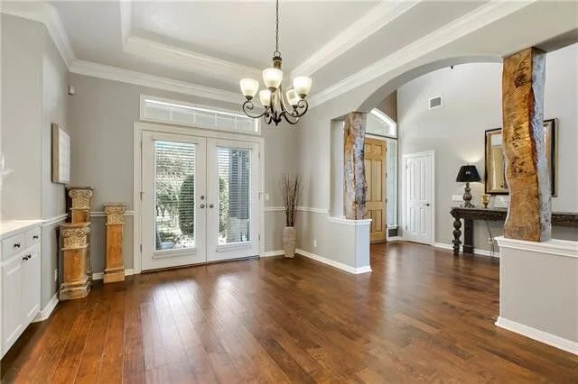 BEFORE  - Dining room looking into entry hall with rustic columns that had to go. carlaaston.com