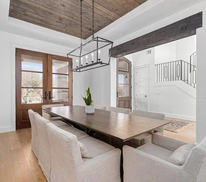 AFTER  - Dining room with new French doors, wood ceiling, lantern light fixture and wood beam header at the entrance to this space helped give it a nice update. carlaaston.com