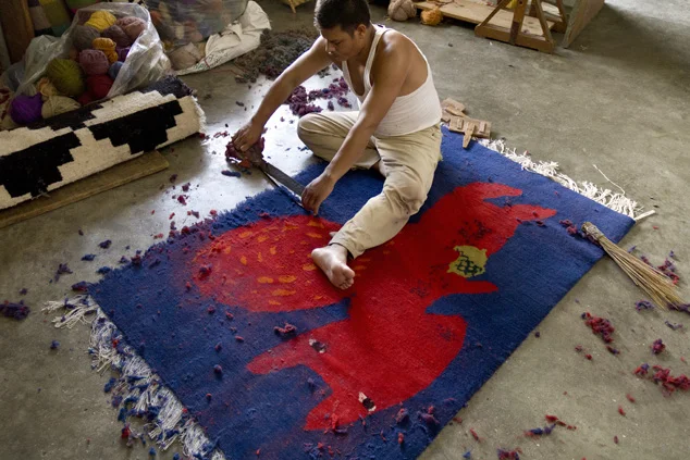 Artisans finishing a rug.