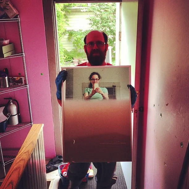 Glen holding up a mirror showing the levels of water. (The mirror had been resting on the basement floor. )
