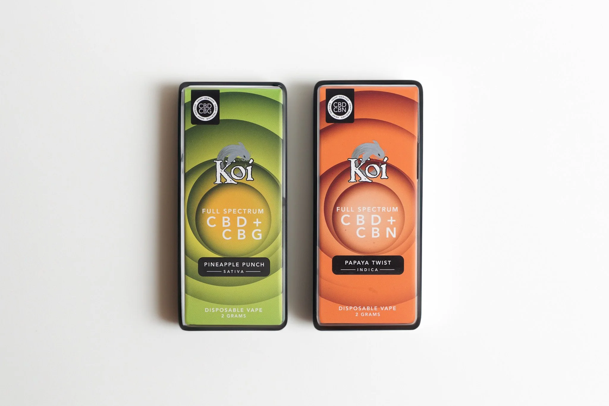 Two boxes of Koi CBD disposable vapes, one labeled Pineapple Punch and the other Papaya Twist, on a white background.