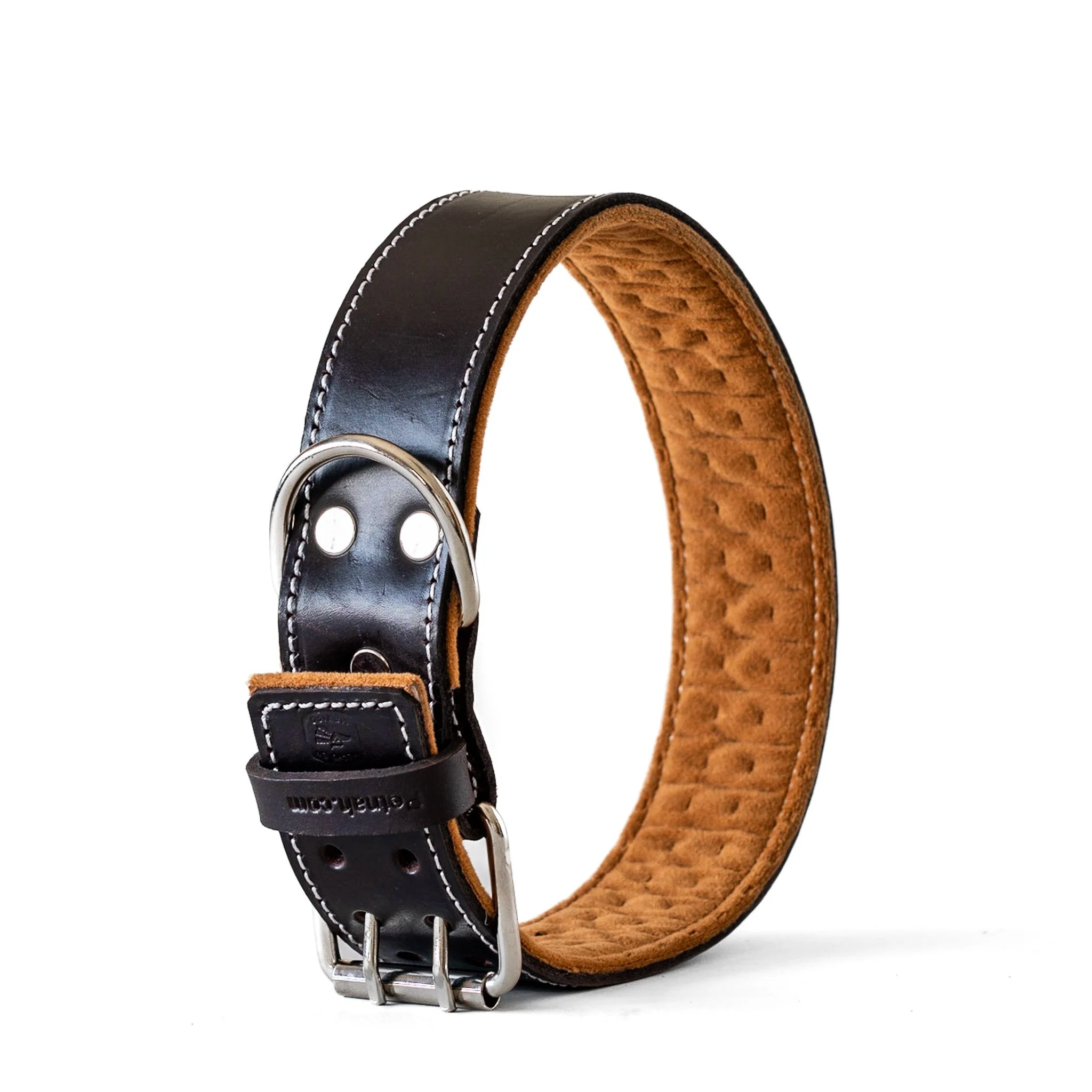 Black leather dog collar with a padded tan interior, silver buckle, and D-ring for leash attachment.