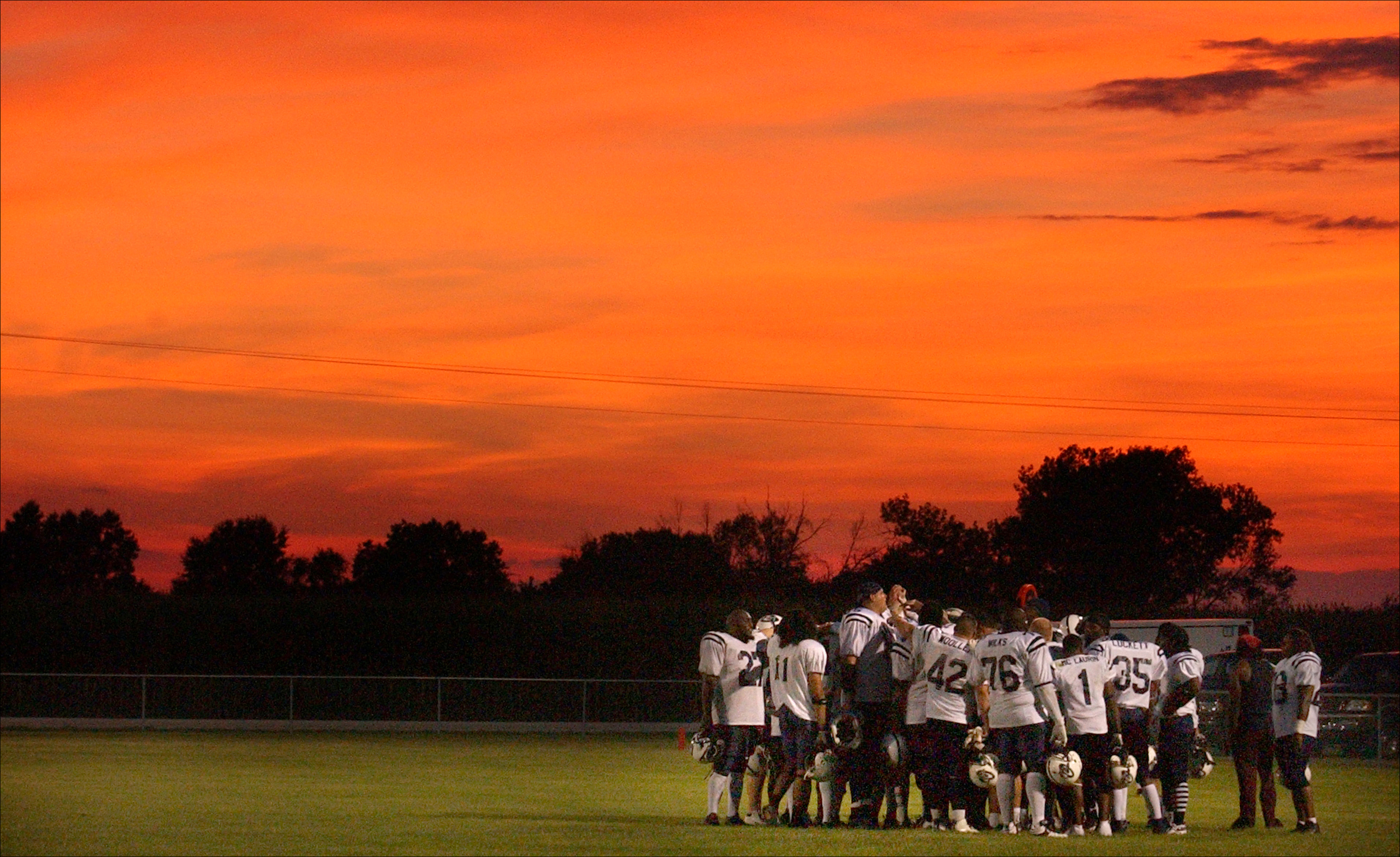  Members of the Northeast Missouri Cyclones briefly went over their strategy for the second half of their game at the Van-Far High School football field in Vandalia, Mo. where temperatures eased down under an orange, summer sky. The minor league foot