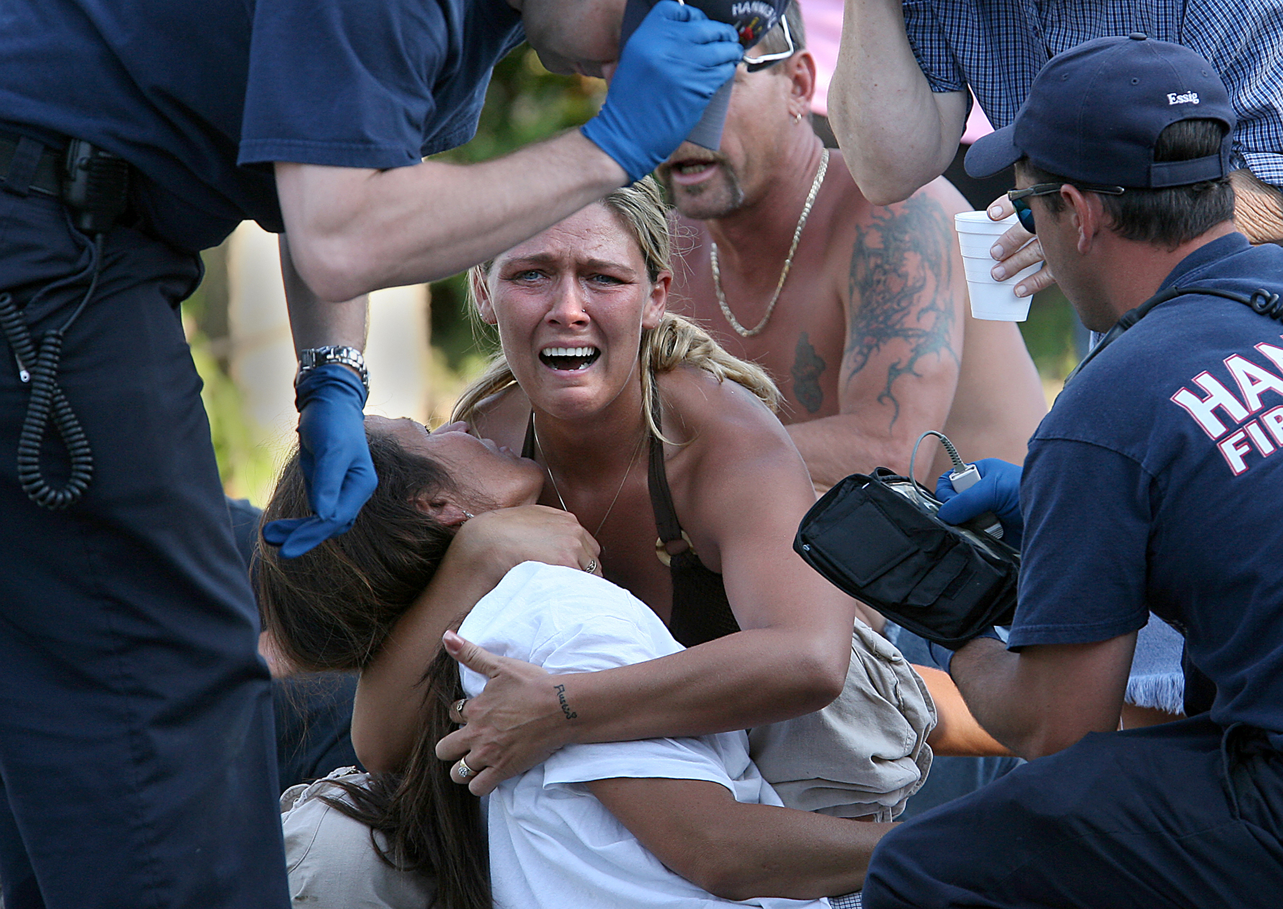  Missy Lane, center, comforts her friend Brenda Charlton, below, as Hannibal EMS workers work to treat Charlton who collapsed after learning her brother, William Rickey, had killed himself in his trailer home at a  Hannibal. Mo. trailer park. 