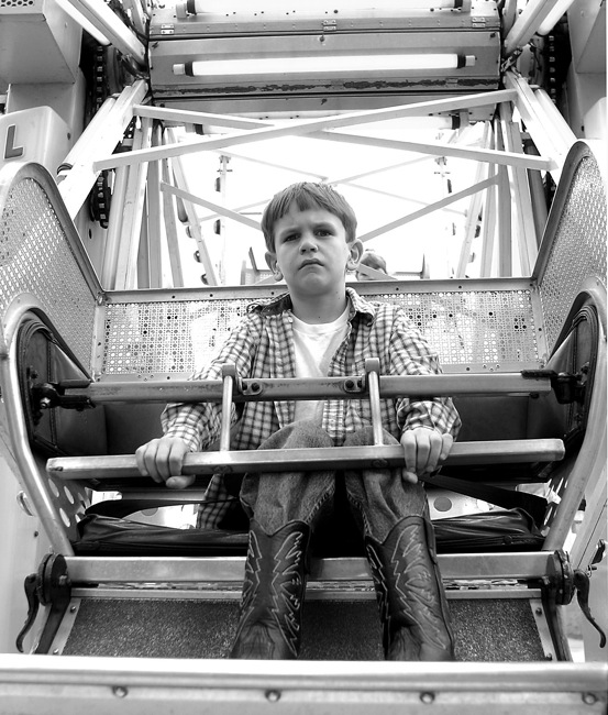  A boy forced to ride the ferris wheel alone.  