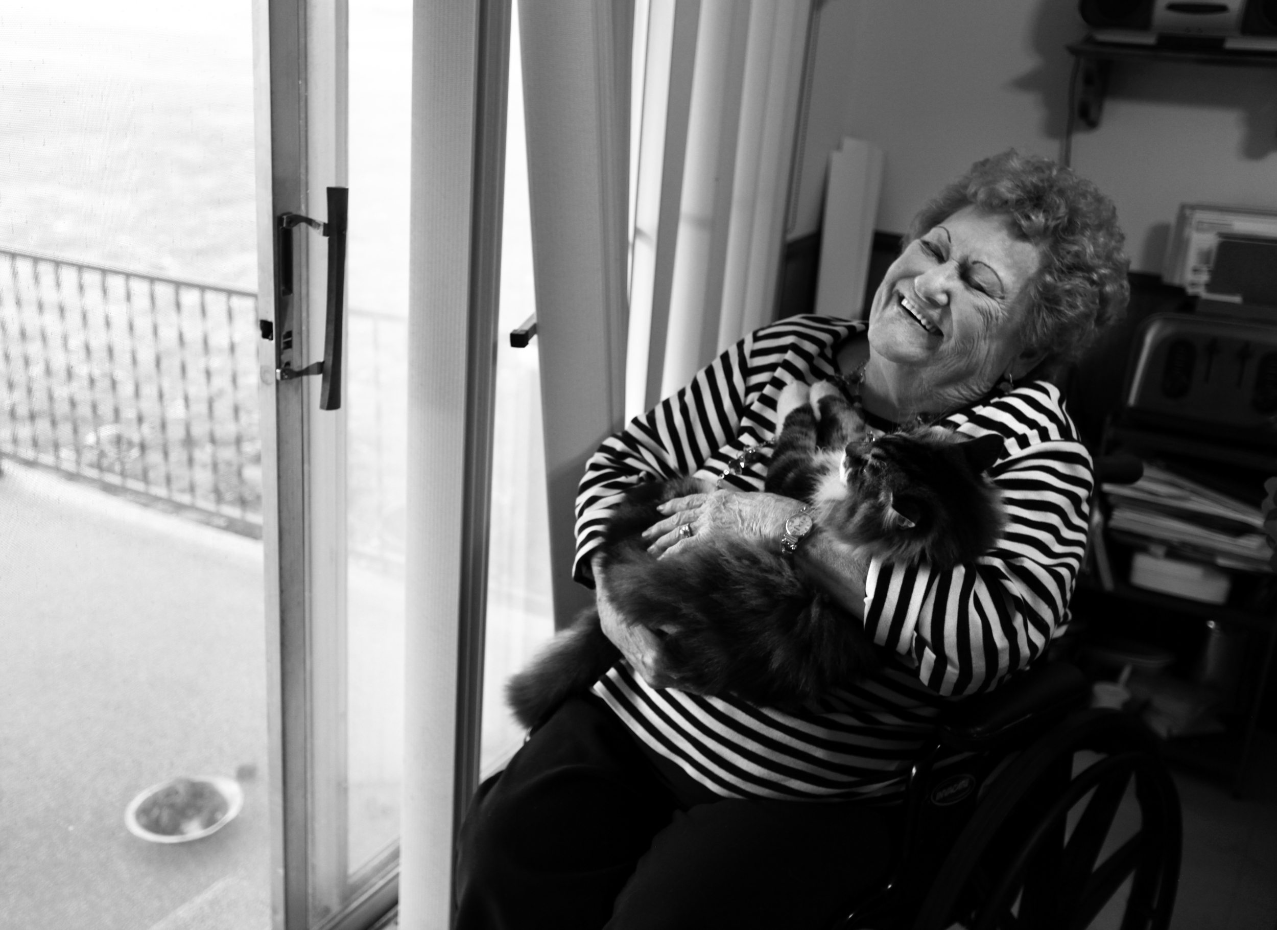  Bonnie Chapman cuddles her cat as she laughs about how she now gets around in her wheelchair after having to have a leg amputated. “I’m still moving. I’m still here. This ain’t going to stop me.” 