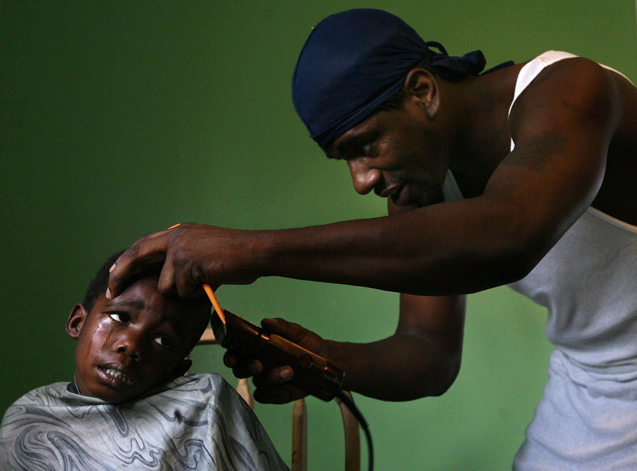 Taylin Jones Abbey, left, tearfully allowed Chris Bradshaw, right, to cut his hair during the 10th annual Back-to-School HELP Fair held at First Baptist Church and the Redmon & Lee Center in Quincy, Illinois. The fair offered free haircuts, scho