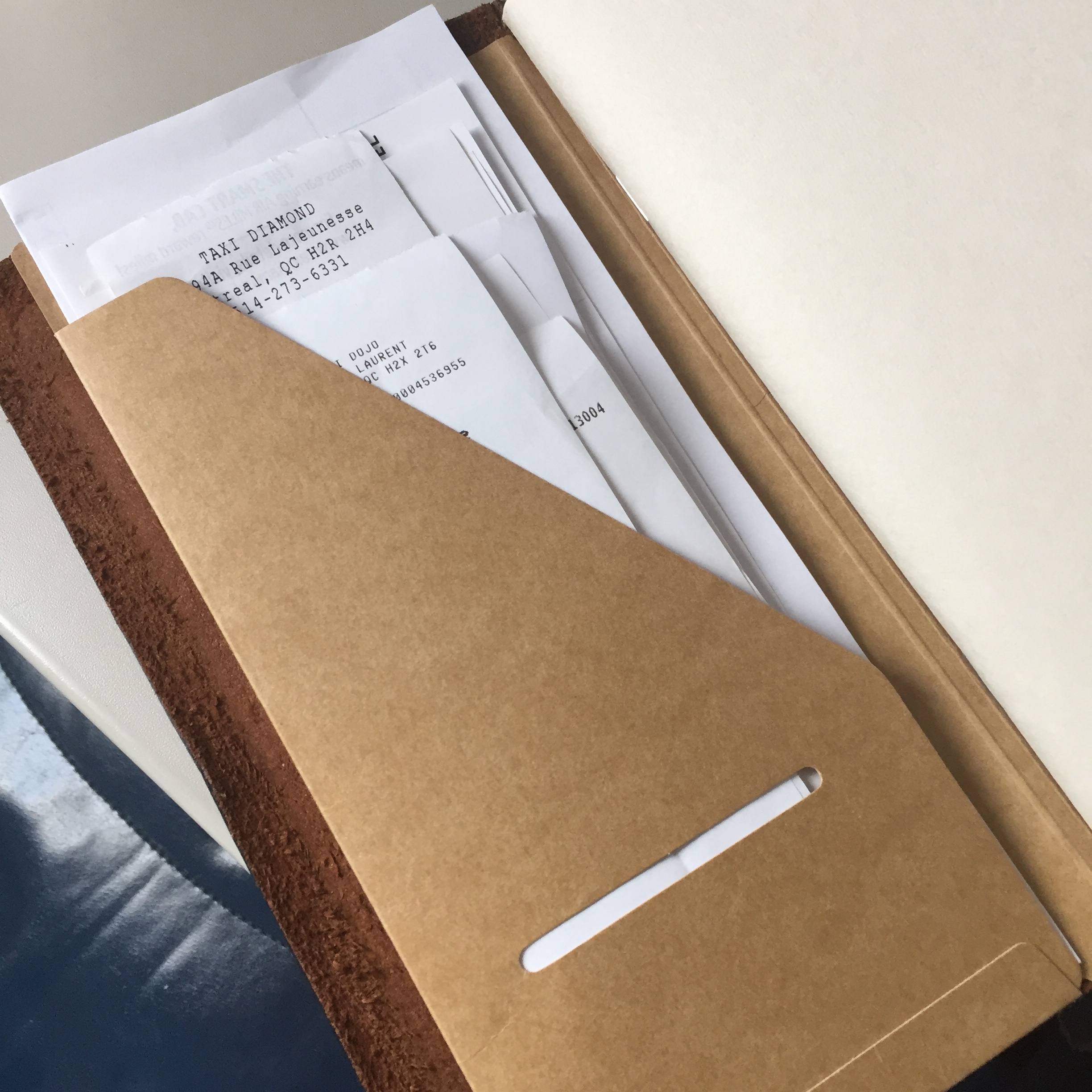 The inside front pocket of the 020 Kraft File Folder stuffed receipts. This photo was taken mid-flight.