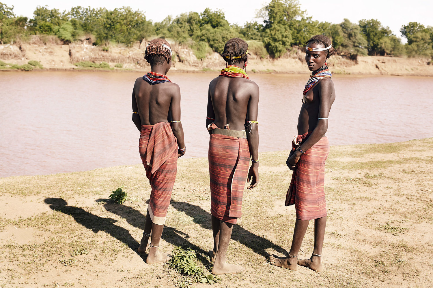DAASANACH GIRLS LOOKING AT THE OPPOSITE OF OMO RIVERBANK, ETHIOPIA